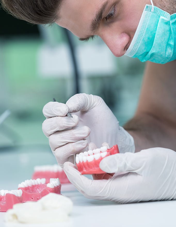 Gloved hands working on a dental implant