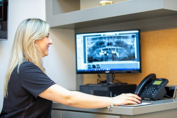 Woman looking at digital x-rays on a computer monitor